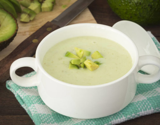 Refreshing avocado soup with yogurt, garnished with fresh herbs and a drizzle of olive oil