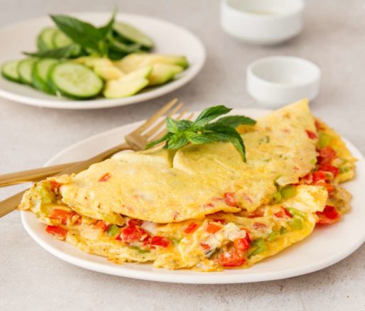 Colorful omelette bursting with vibrant vegetables and flavorful herbs.